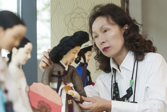 김혜순 교수가 인형을 매만지는 모습